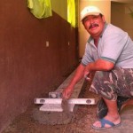 Juan applying the tile on the floor of church